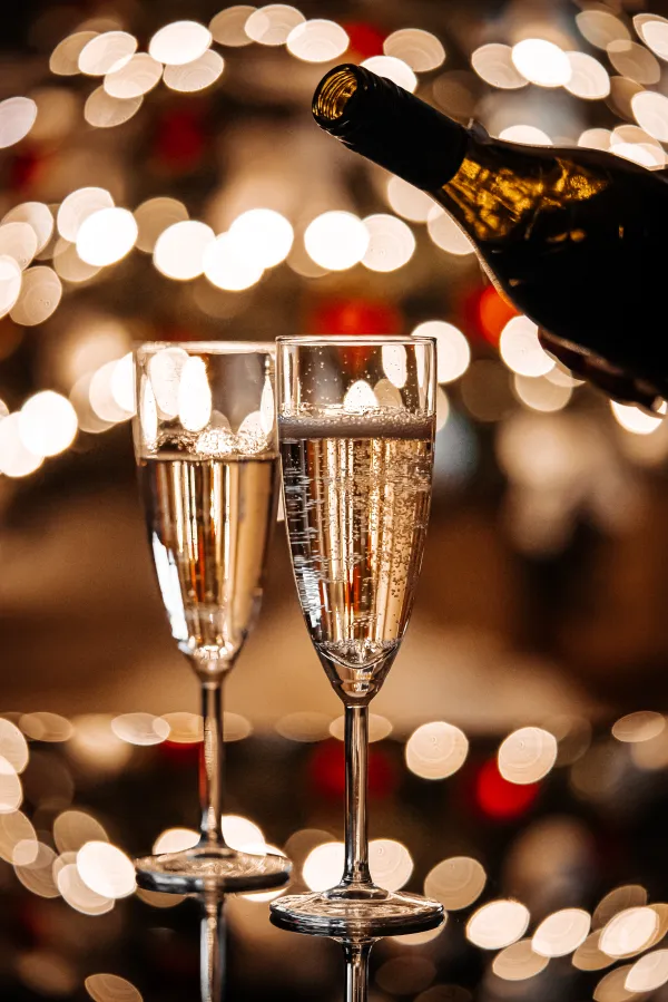 pouring champagne during new years eve with bokeh free photo